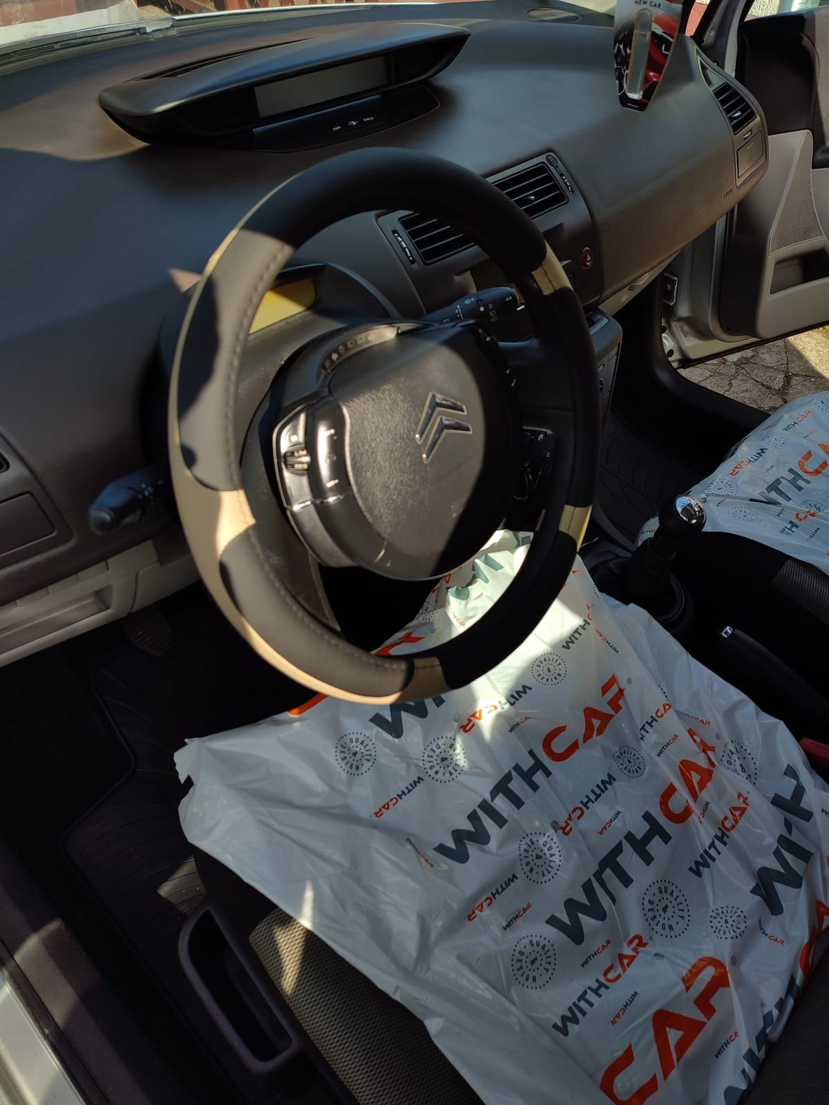 A Citroën C4 műszerfala és kormánya a takarítás után, felhelyezett ülésvédővel